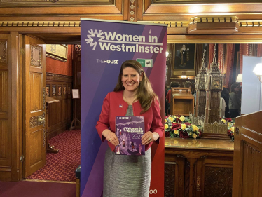 Theo Clarke MP holding her copy of Women in Westminster: The 100